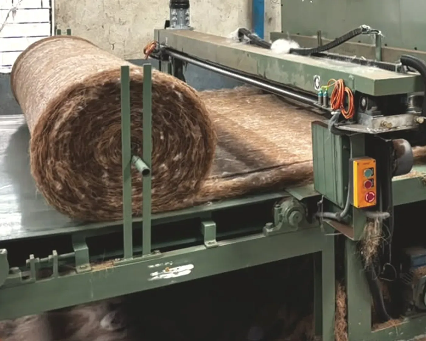 A finished roll of coir needle felt coming off the line